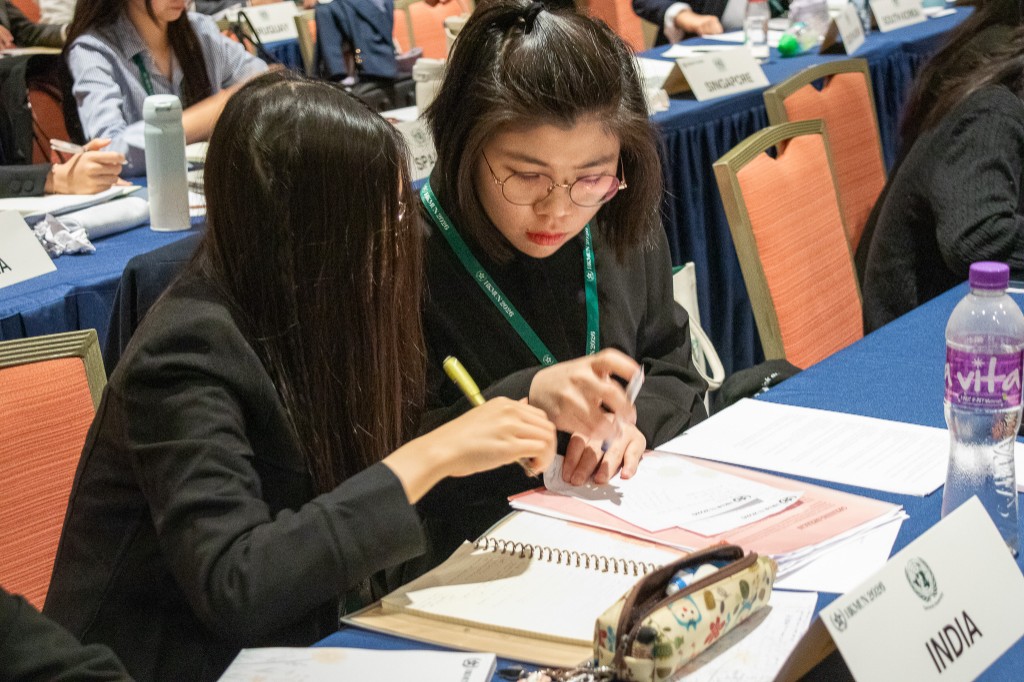 Two delegates reviewing papers at India table